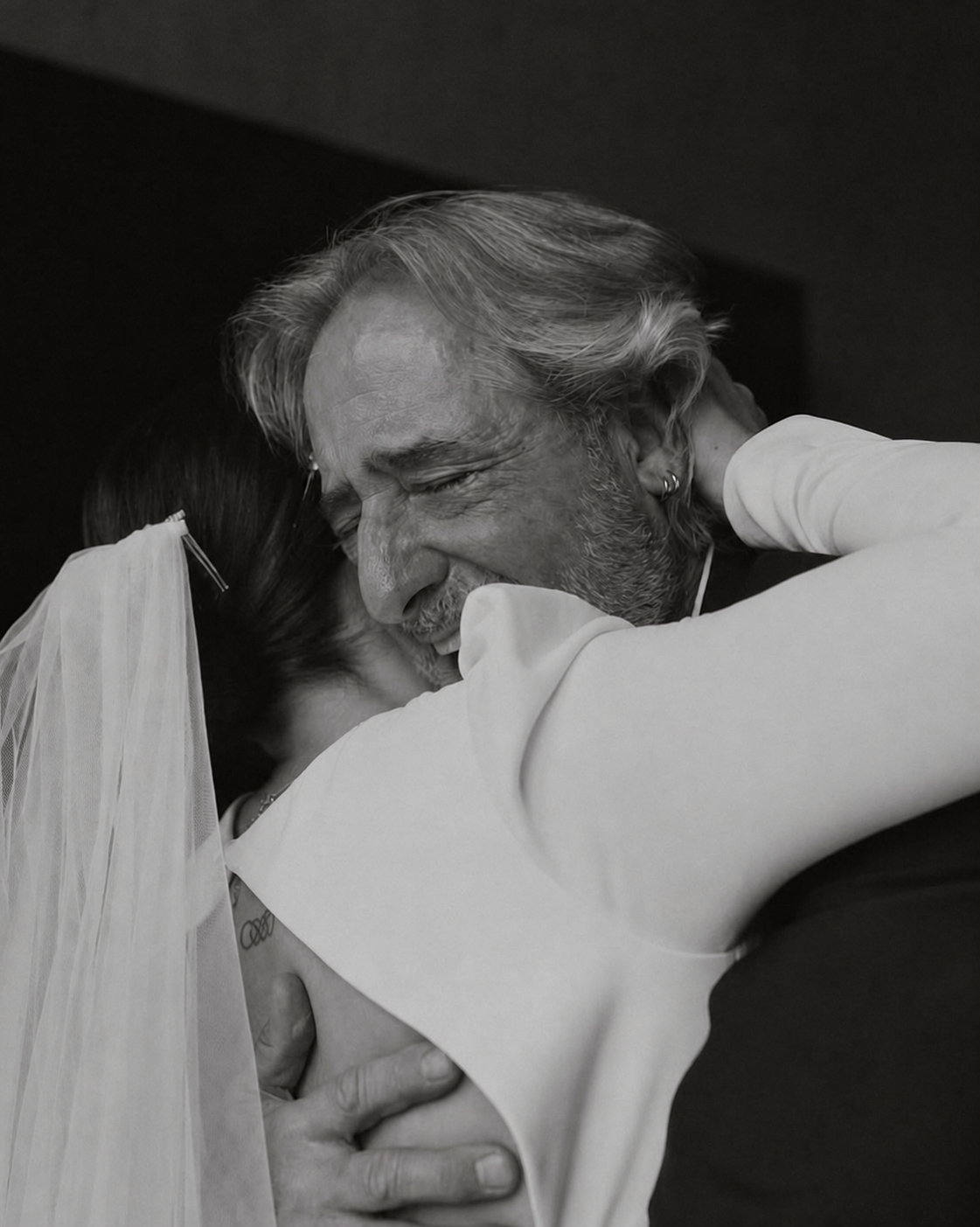 Padre abrazando con emoción a la novia en blanco y negro