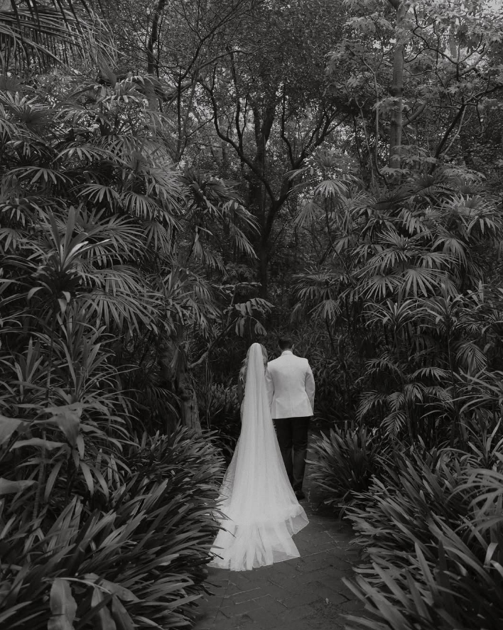 Pareja caminando entre vegetación tropical en blanco y negro